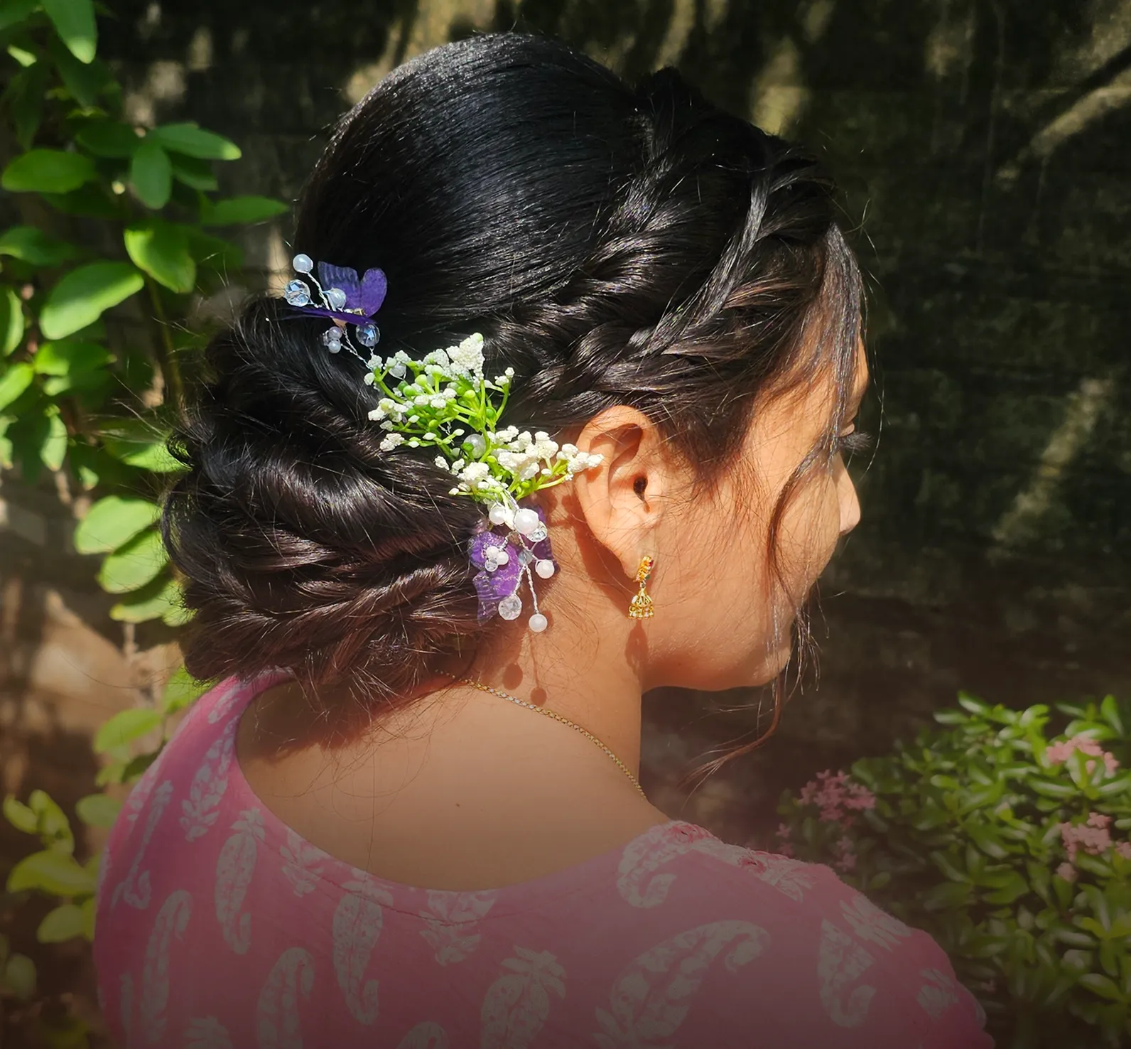 Low bun styled with small flower pins, seen from behind